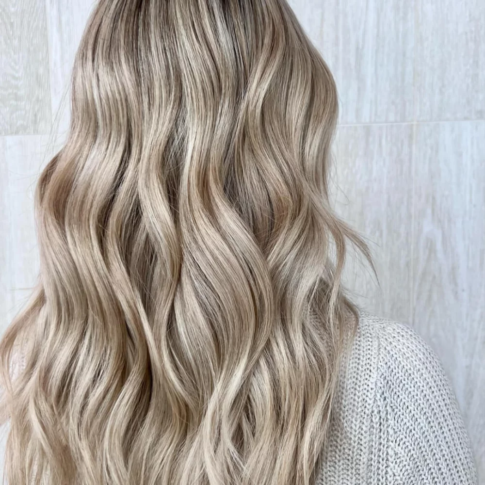 Vue arrière de cheveux blonds bouclés avec des mèches claires